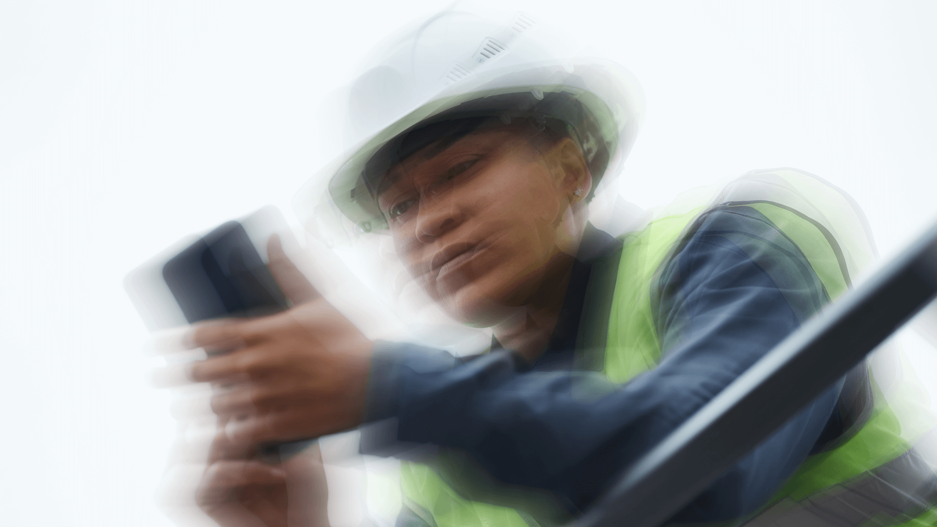 Construction worker in high-vis gear using a smartphone